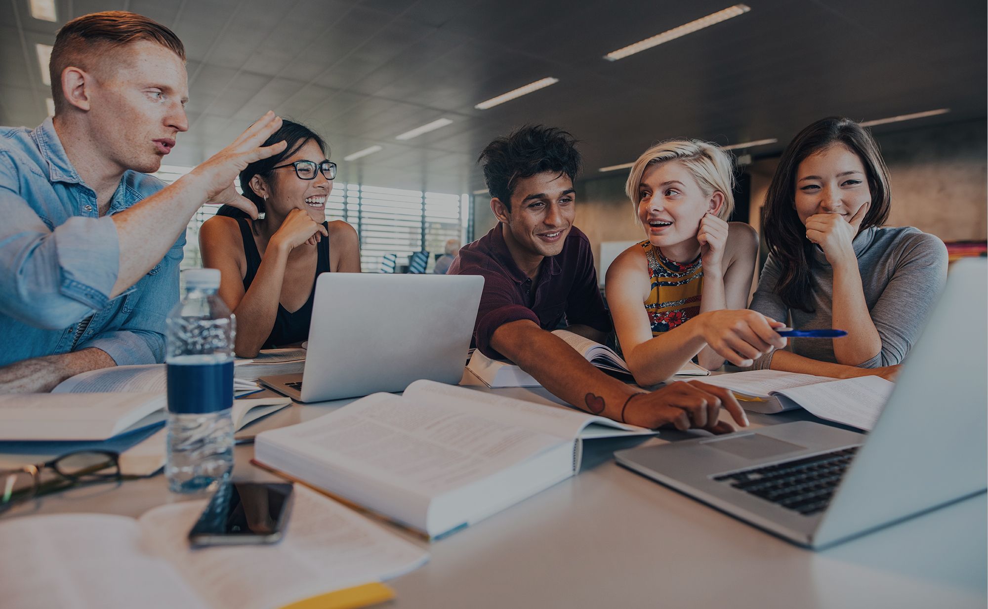Diverse team of young professionals collaborating on a tech project in a modern office.