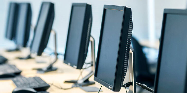 Modern computer workstations in a tech lab environment at Softinator TechLabs.