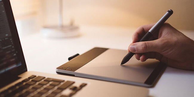 Modern workspace with digital drawing tablet and laptop for AI development.