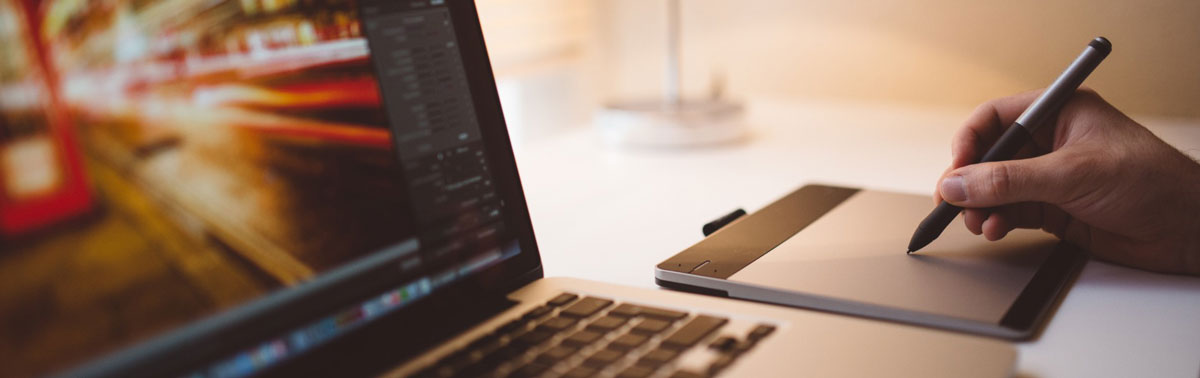 Modern workspace with digital drawing tablet and laptop for AI development.