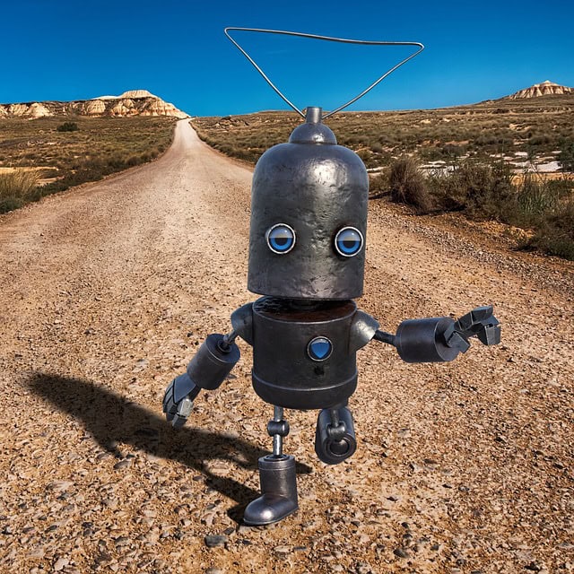 AI robot walking on dirt road in a desert setting.