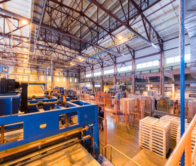 Modern factory interior with automated machinery and pallets for efficient production.