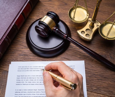 Legal and judicial gavel with scales of justice, symbolizing law and governance, on a wooden desk.