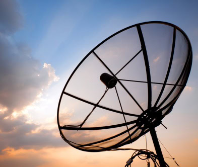 Satellite dish antenna against sunset sky, representing telecom technology.