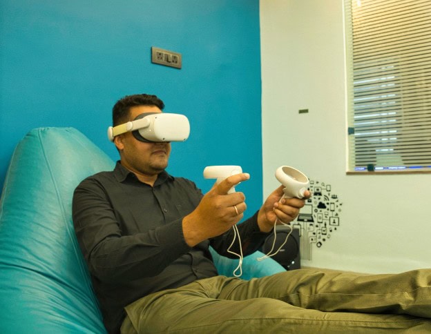 Person using VR headset and controllers for immersive AR gaming.