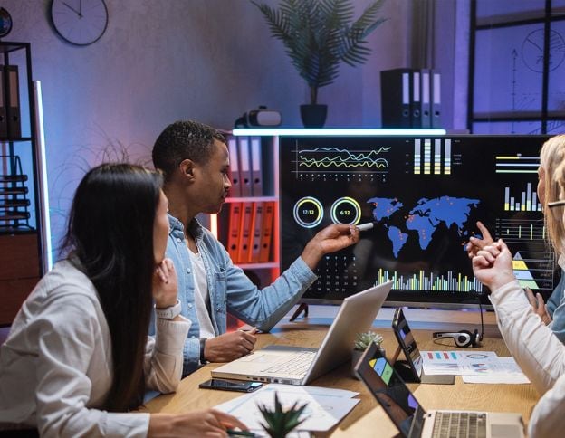 Business Intelligence & Analytics team analyzing data on a large screen.