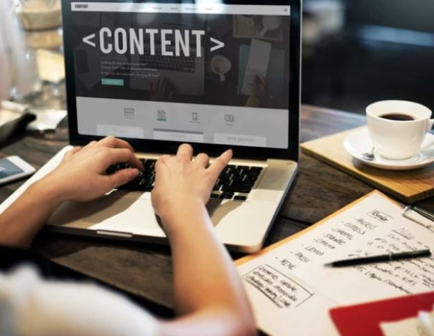 Person working on a laptop with CMS content management interface.