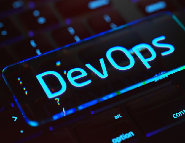 DevOps and CI/CD concepts displayed on a digital keyboard with glowing text.