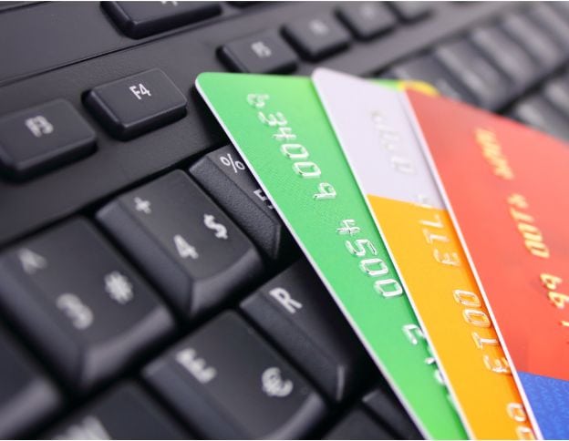 Digital payment cards on a keyboard for online shopping.
