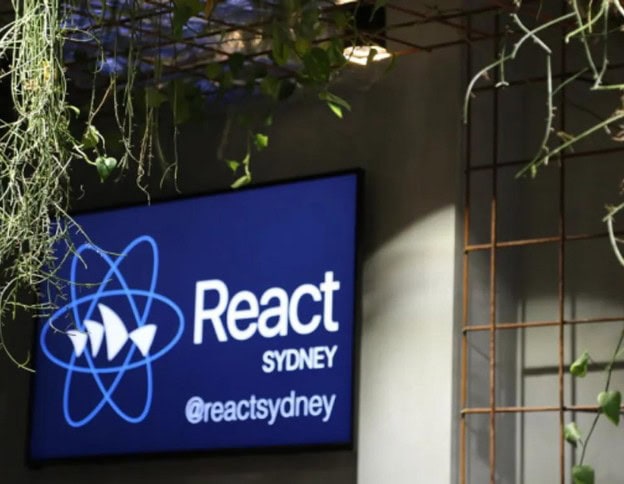React Conference Sydney sign with React logo and social handle.