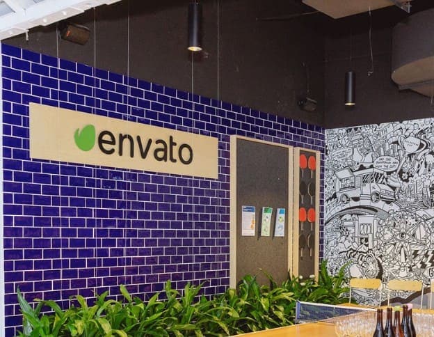 Modern office wall with Envato logo and creative mural background.