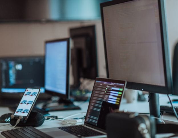 Modern WPF development setup with multiple monitors and coding tools.