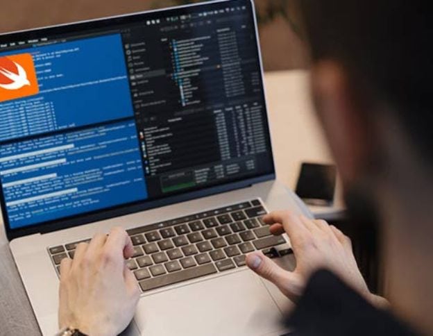 Software developer working on Swift code on a laptop screen.