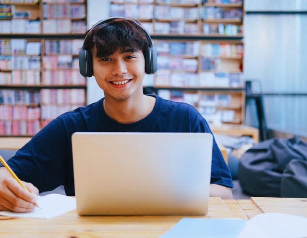 Young developer working on AI and ML projects in a library setting.