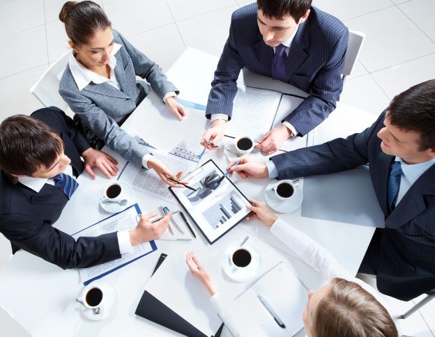 Business professionals collaborating on IT solutions at a meeting.