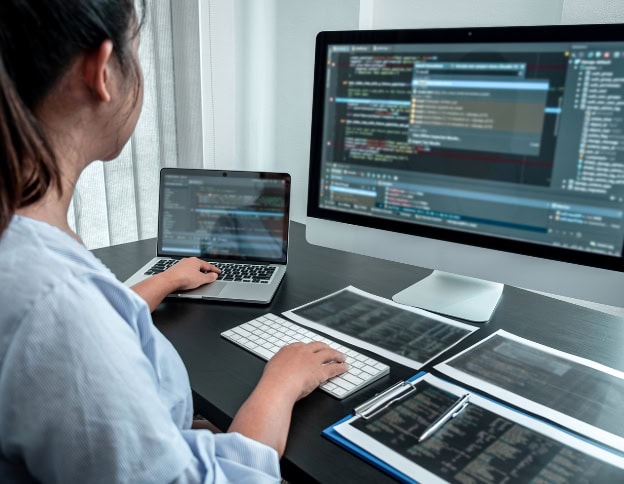 Woman working on cybersecurity coding at Softinator TechLabs.