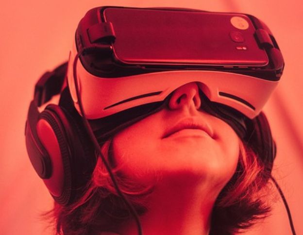 Person using VR headset and headphones for immersive experience.