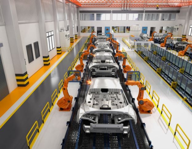 Robotic arms assembling vehicles in a modern factory.