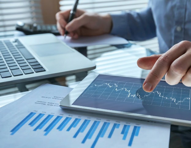 Business analyst using tablet with data charts and graphs.