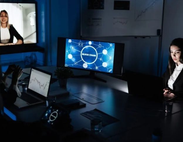 Team analyzing blockchain network on multiple screens in a high-tech office.