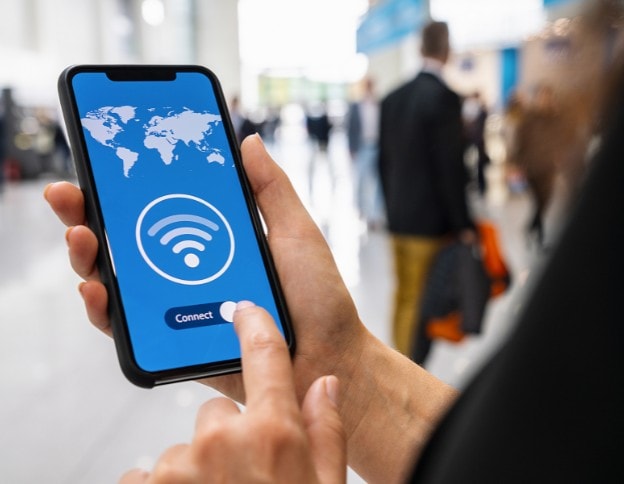 Person connecting to Wi-Fi on smartphone at a busy event.
