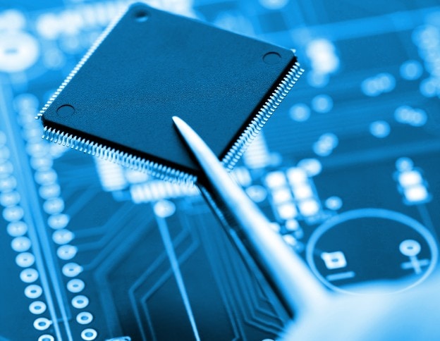 Microcontroller on circuit board with pen, used in AI and ML development.