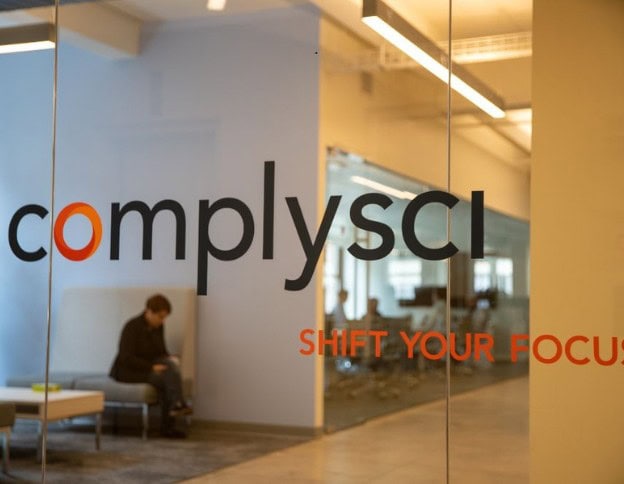 Softinator TechLabs office with "complysci" logo and "Shift Your Focus" slogan.