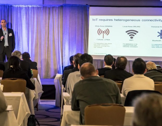 Presenter explaining IoT connectivity options to an audience at a conference.