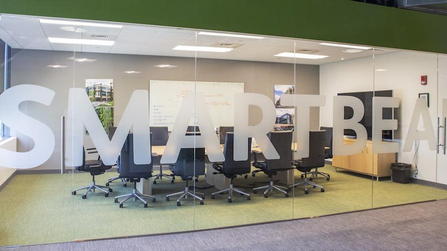Modern conference room with "SMART" and "BEA" signage for software testing and QA.