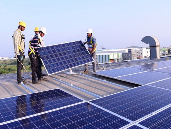 Team installing solar panels on a rooftop for renewable energy solutions.