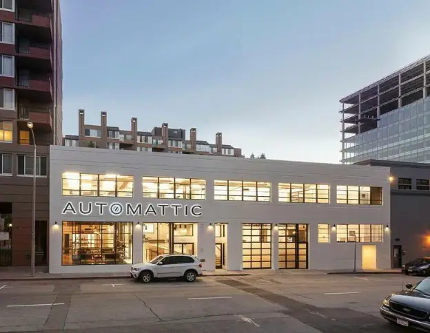 Modern commercial building with "Automatic" sign, city street view.