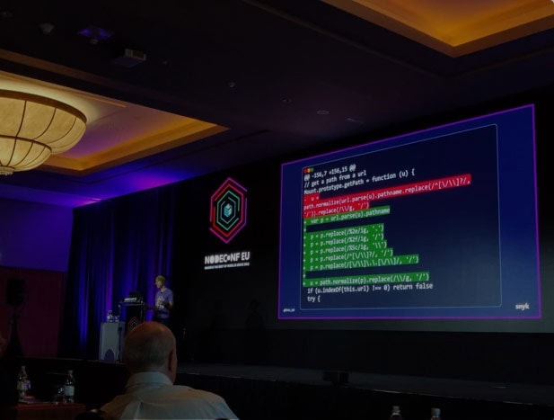 AI and ML coding on a large screen at a tech conference.