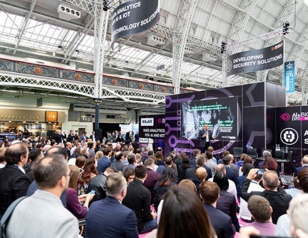 Large audience attending an AI and data analytics conference at a tech event.
