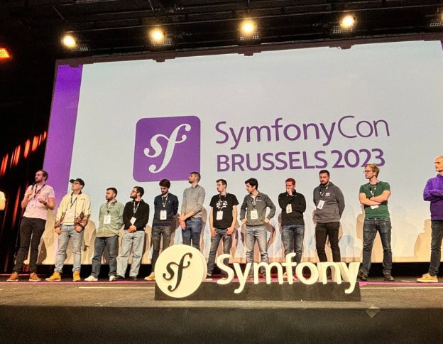 Group of developers on stage at SymfonyCon Brussels 2023 event.