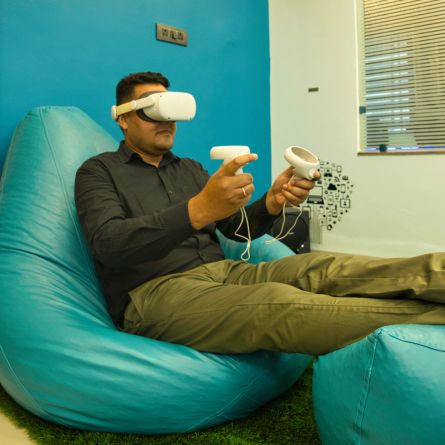 Man using VR headset and controllers in a modern office setting.