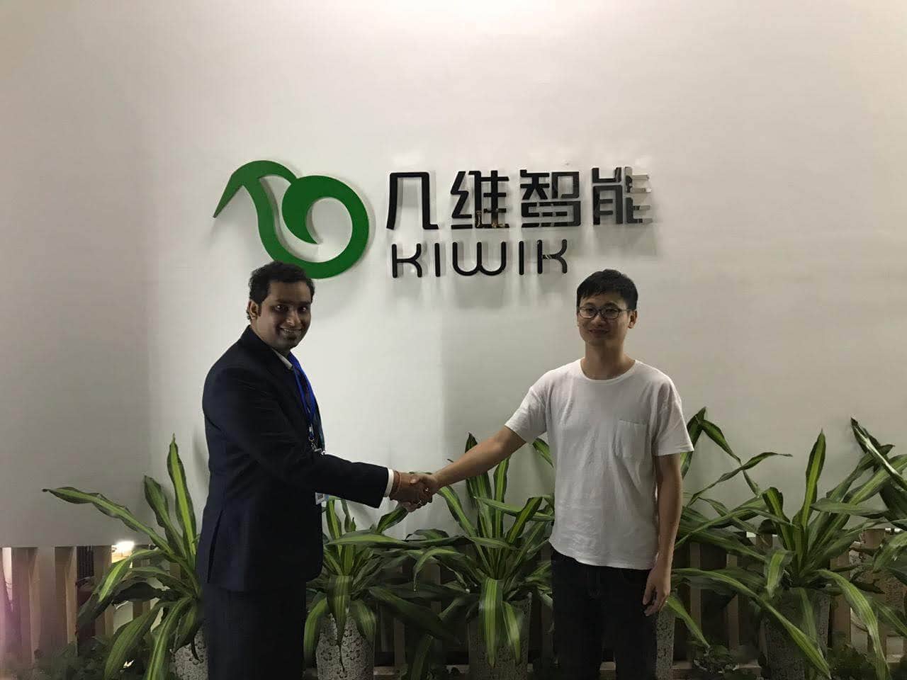 Two men shaking hands in front of Softinator logo at TechLabs event.