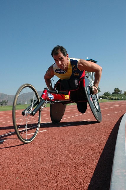 Accessible sports wheelchair on running track during athletic event.