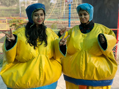 Two women in yellow protective suits posing at Softinator TechLabs.