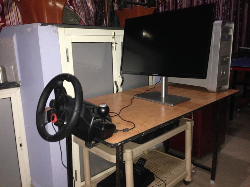 Computer workstation with steering wheel and monitor at Softinator TechLabs.