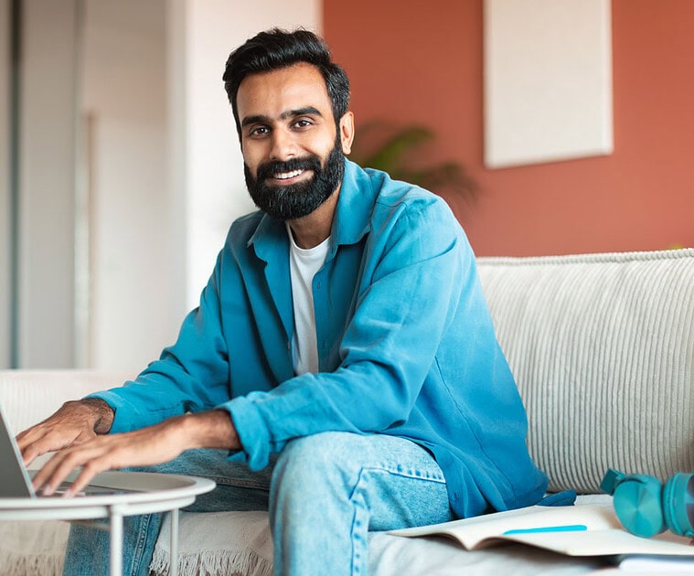 Man working remotely on a laptop with Softinator's digital collaboration tools.