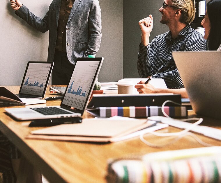 Business development executive presenting to team in a modern office.